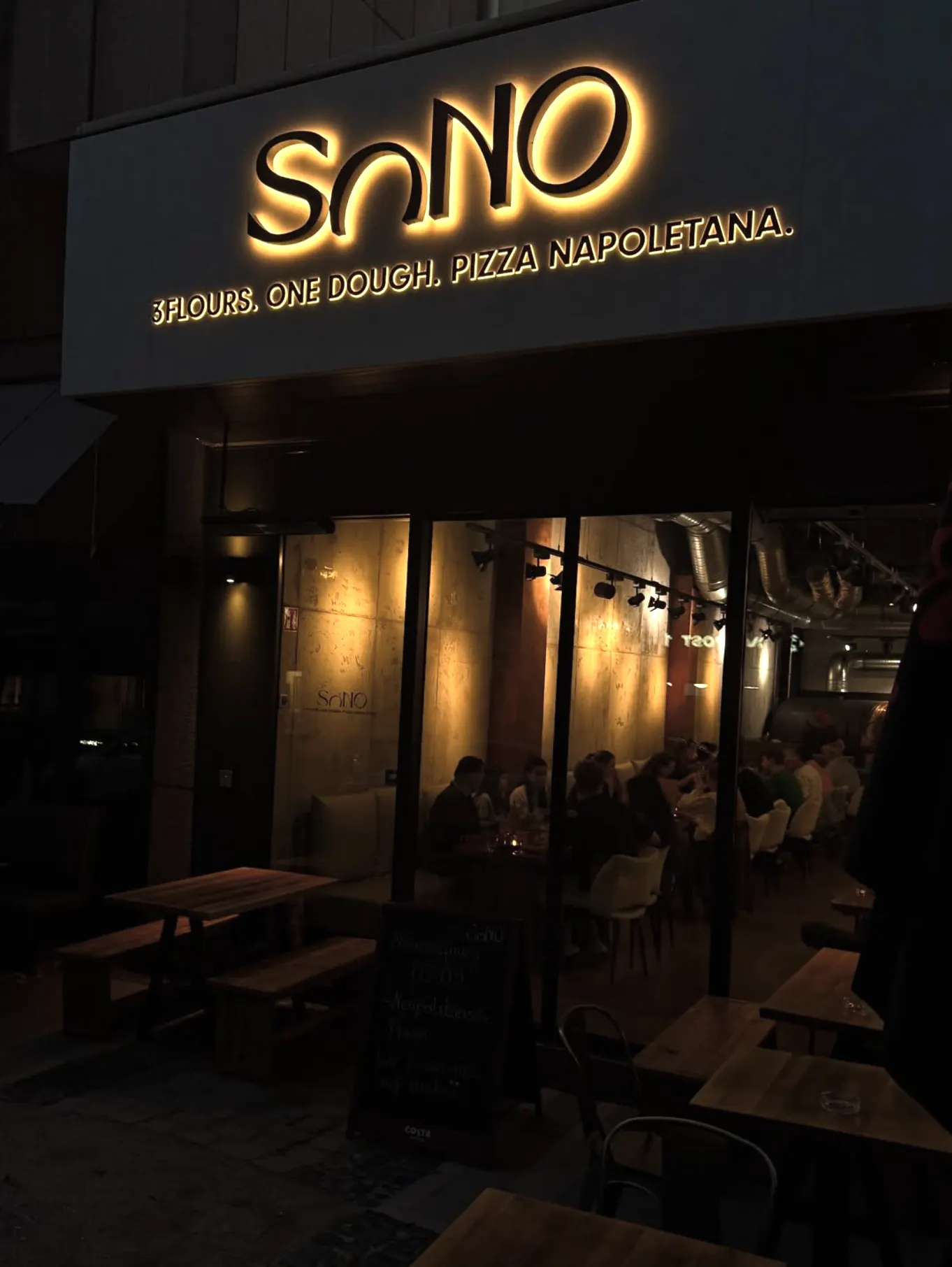 Die Fassade von SONO bei Nacht mit beleuchtetem Schriftzug