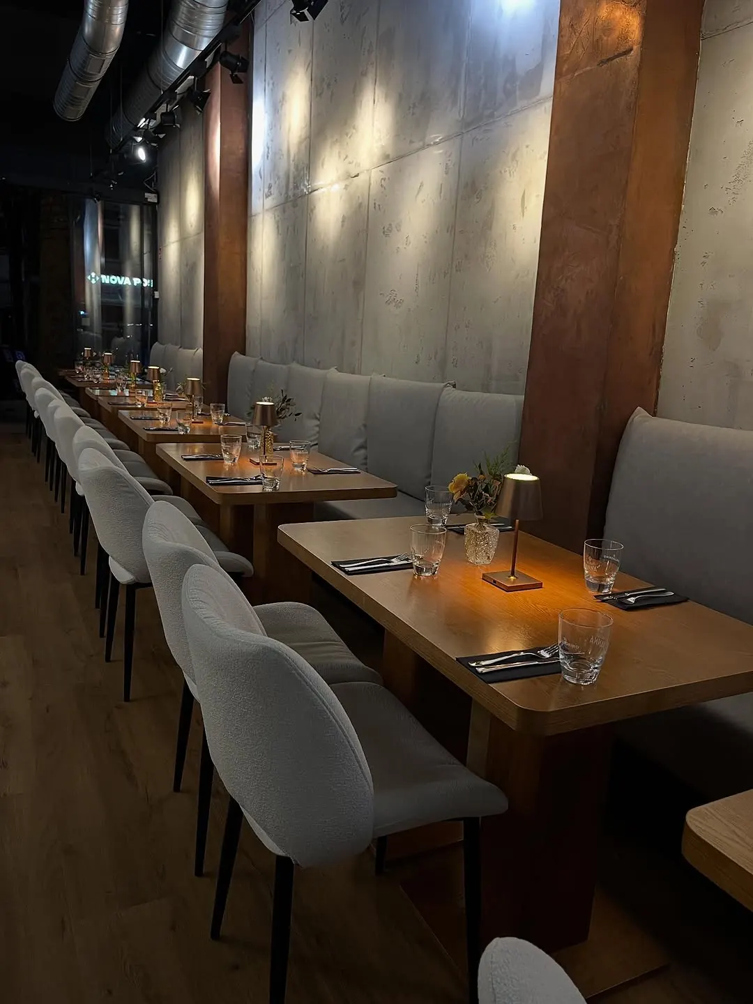 Gedeckter Tisch mit Blumen und Tischlampe im Abendlicht
